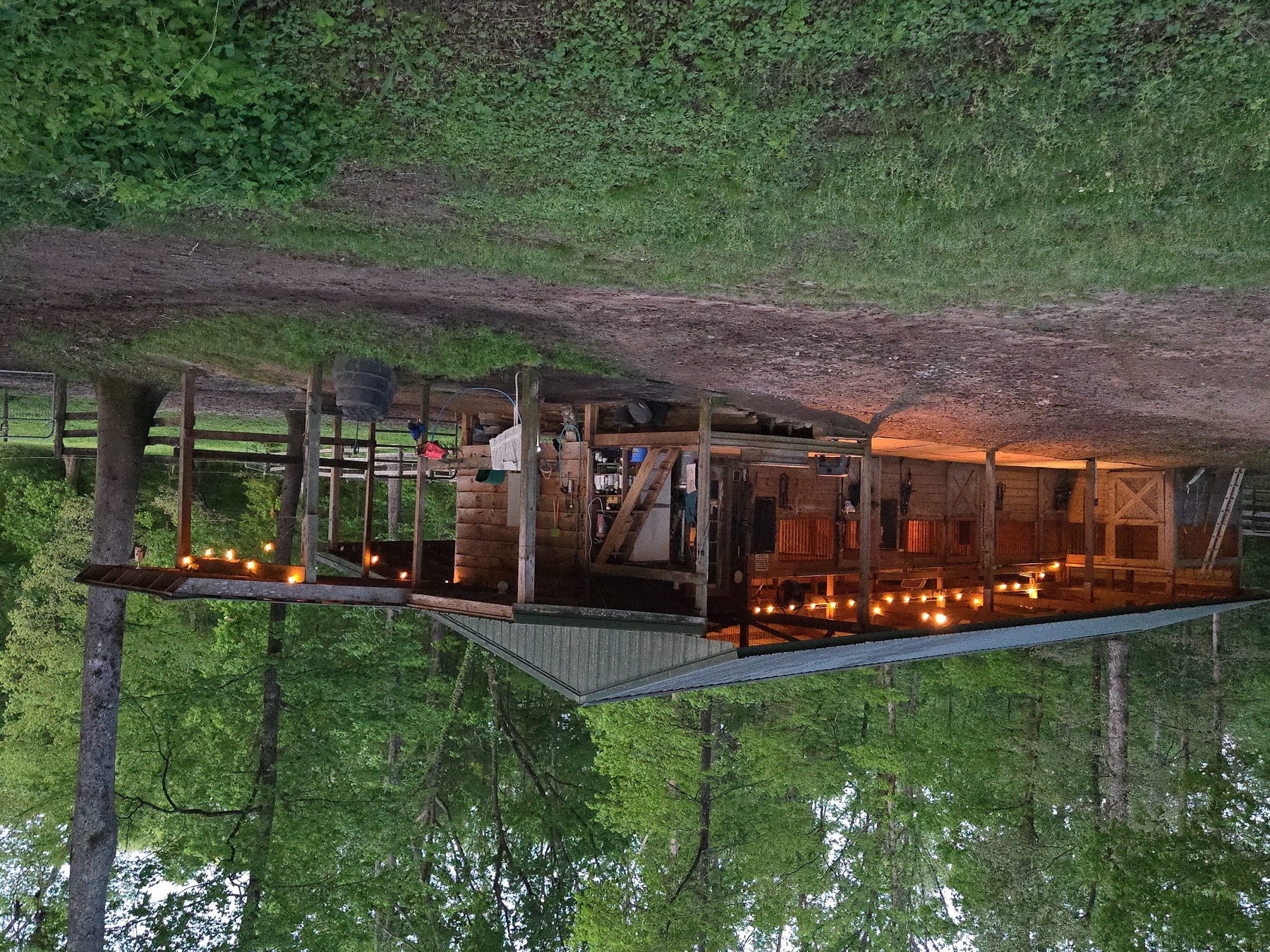 Horse barn at Flying Changes Farm with lights on at dusk